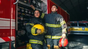 Bomberos voluntarios junto a una autobomba (imagen ilustrativa genérica, no del operativo puntual en Ezpeleta - banco de imágenes Pexels)
