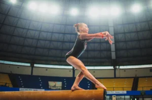 Gimnasta realizando un ejercicio de viga en una competencia de gimnasia artística (imagen ilustrativa genérica, banco de imágenes Pexels)
