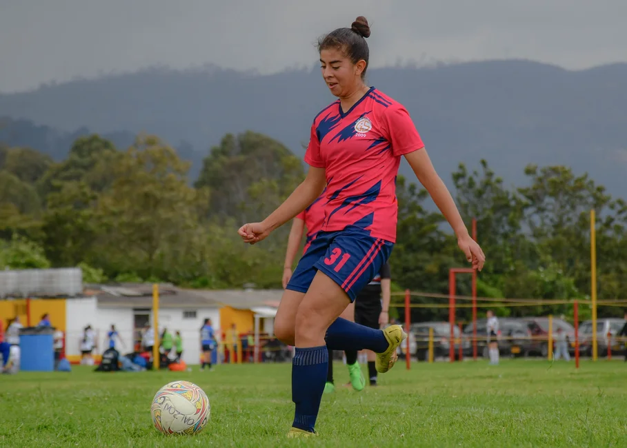 Jugadora de fútbol femenino en un campo de césped (imagen ilustrativa genérica, banco de imágenes Pexels)