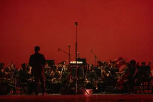 Orquesta actuando en un escenario (imagen ilustrativa genérica, banco de imágenes Pexels)