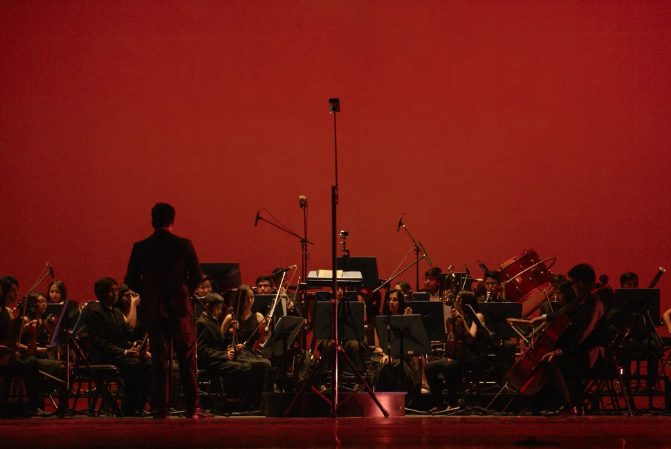 Orquesta actuando en un escenario (imagen ilustrativa genérica, banco de imágenes Pexels)