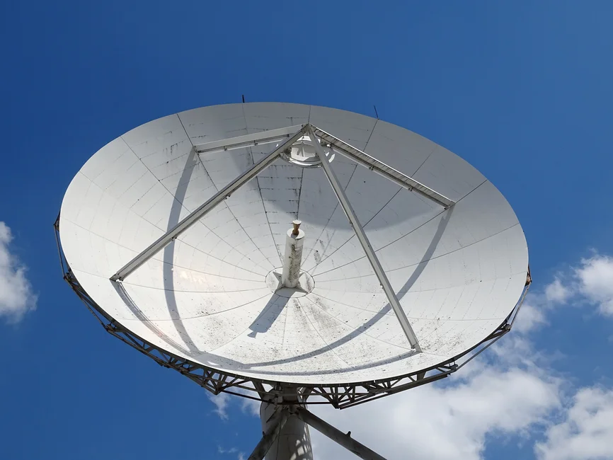 Antena satelital de gran tamaño contra un cielo azul (imagen ilustrativa genérica)