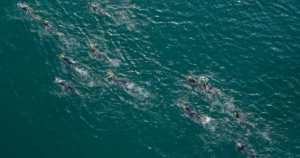 Nadadores compitiendo en una carrera de aguas abiertas (imagen ilustrativa genérica, banco de imágenes Pexels)