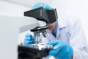 Un científico observa una muestra al microscopio en un laboratorio (imagen ilustrativa genérica, banco de imágenes Pexels; no corresponde al laboratorio real del CONICET/Universidad Austral)