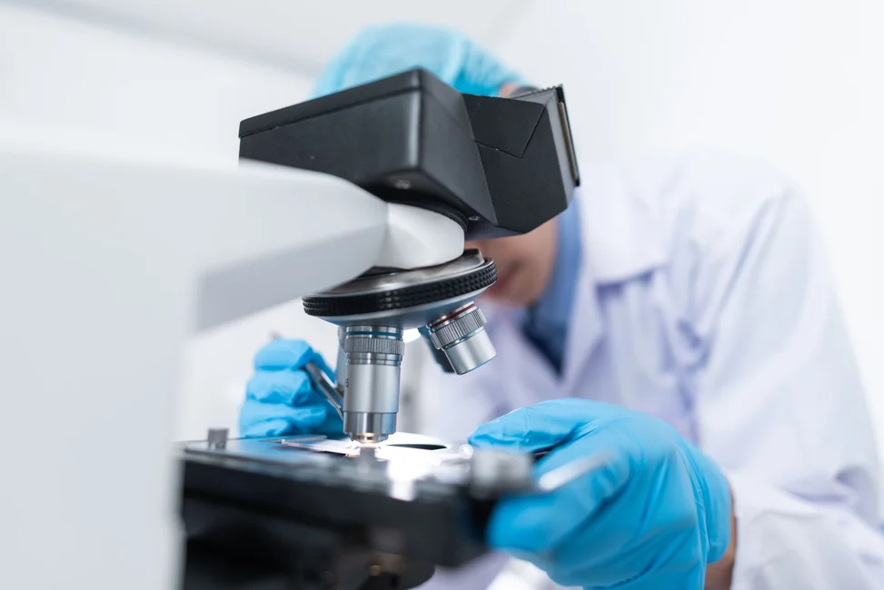 Un científico observa una muestra al microscopio en un laboratorio (imagen ilustrativa genérica, banco de imágenes Pexels; no corresponde al laboratorio real del CONICET/Universidad Austral)