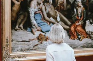 Una persona observa una pintura clásica en un museo (imagen ilustrativa genérica, banco de imágenes Pexels; la obra que se ve en la foto no es el cuadro real restituido en Mar del Plata)