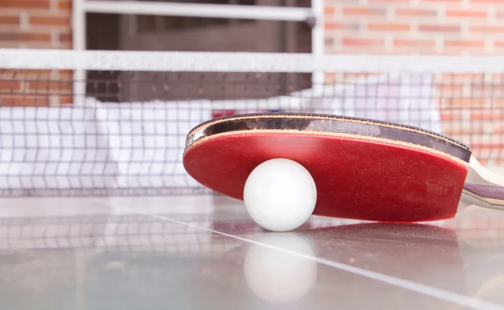 Paleta y pelota de tenis de mesa sobre una mesa (imagen ilustrativa genérica, sin relación directa con el hecho puntual). Banco: Pexels, foto de Sascha Düser.