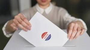 Persona depositando su voto en una urna. Imagen ilustrativa genérica, no corresponde a la protagonista real de la nota (banco de imágenes: Pexels, foto: Edmond Dantes).