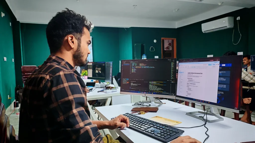 Persona trabajando con computadoras en una oficina (imagen ilustrativa genérica). Banco de imágenes: Pexels, foto de Zayed Hossain.