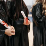 Graduados con togas académicas sosteniendo diplomas. Imagen ilustrativa genérica (banco de imágenes: Pexels, foto de Pavel Danilyuk), no corresponde a la ceremonia real de la UBA.