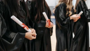 Graduados con togas académicas sosteniendo diplomas. Imagen ilustrativa genérica (banco de imágenes: Pexels, foto de Pavel Danilyuk), no corresponde a la ceremonia real de la UBA.