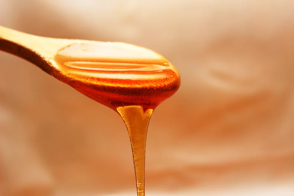 Miel cayendo de una cuchara de madera. Imagen ilustrativa genérica, banco de imágenes Pexels (fotógrafo: Pixabay).