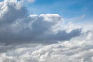 Un avión visto a la distancia entre nubes. Imagen ilustrativa genérica de aviación, banco de imágenes Pexels (fotógrafo: Brett Sayles).